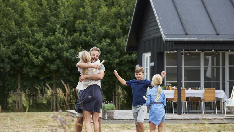 Famile som klemmer utenfor et feriehus i Danmark