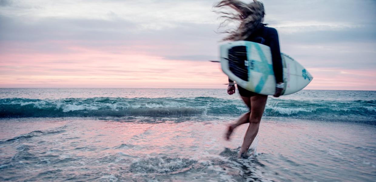 Surfer på stranden i Klitmøller Cold Hawaii på nordvestkysten av Danmark