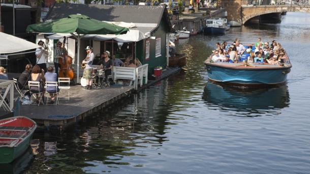 A floating bar and a canal tour boat on the Copenhagen canal