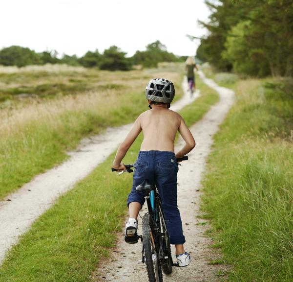 Gutt sykler på en landevei på Fanø, Danmark