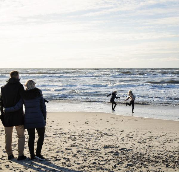 Foreldre og barn leker på standen på høsten i Søndervig, Vesterhavet, Danmark